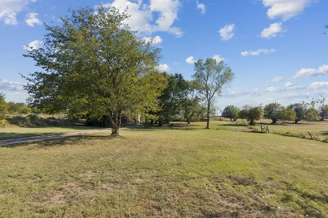 a view of pool with outdoor seating and covered with trees