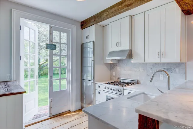 a kitchen with granite countertop a stove a sink and a refrigerator