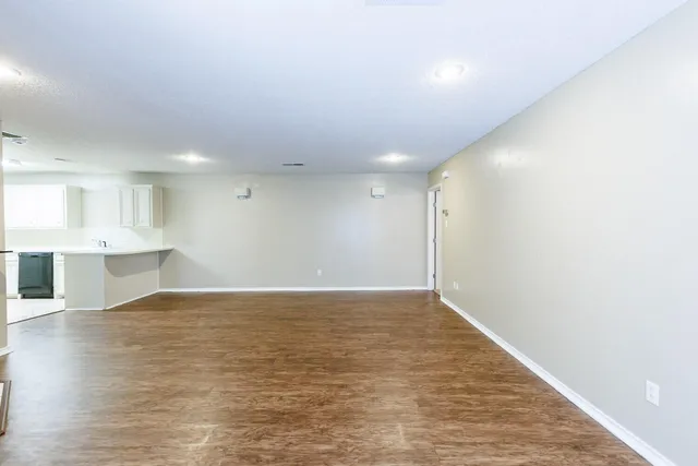 an empty room with wooden floor and fireplace