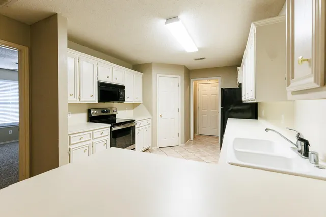 a kitchen with a refrigerator stove and cabinets