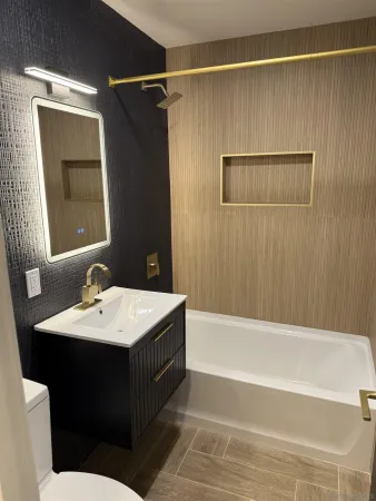 a bathroom with a sink vanity tub and a mirror