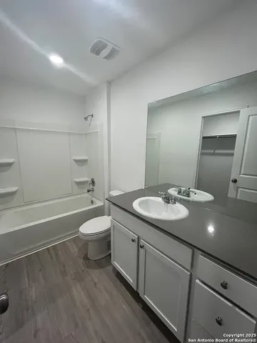 a bathroom with a granite countertop sink toilet and shower