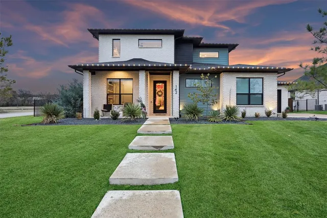 a front view of a house with a yard and trees