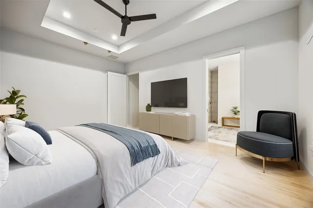 a bedroom with a bed a couch and a flat screen tv