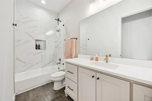 a bathroom with a sink a toilet and a large mirror