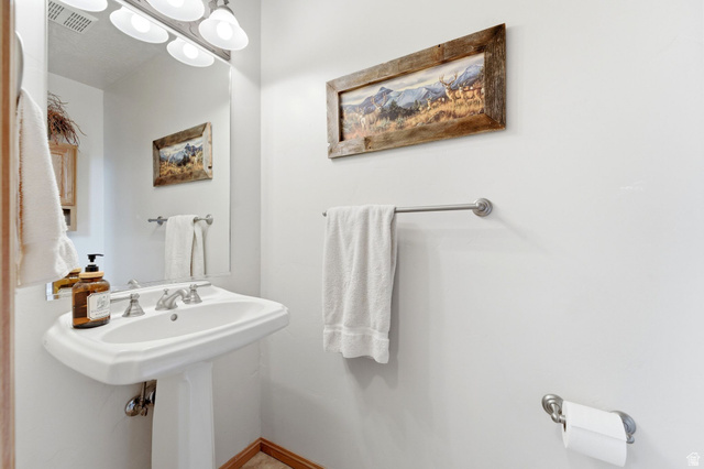 3634 North Huntsman Path, Unit C203 Eden, UT 84310 - Photo 14 of 27 White pedestal sink with a dual-handle faucet, illuminated by a four-light vanity fixture