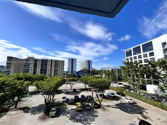 a view of a patio with lawn chairs potted plants and a large tree