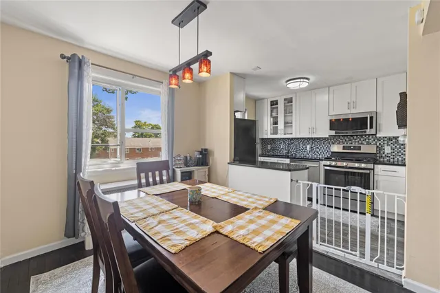 a kitchen with a table chairs a sink dishwasher window and cabinets