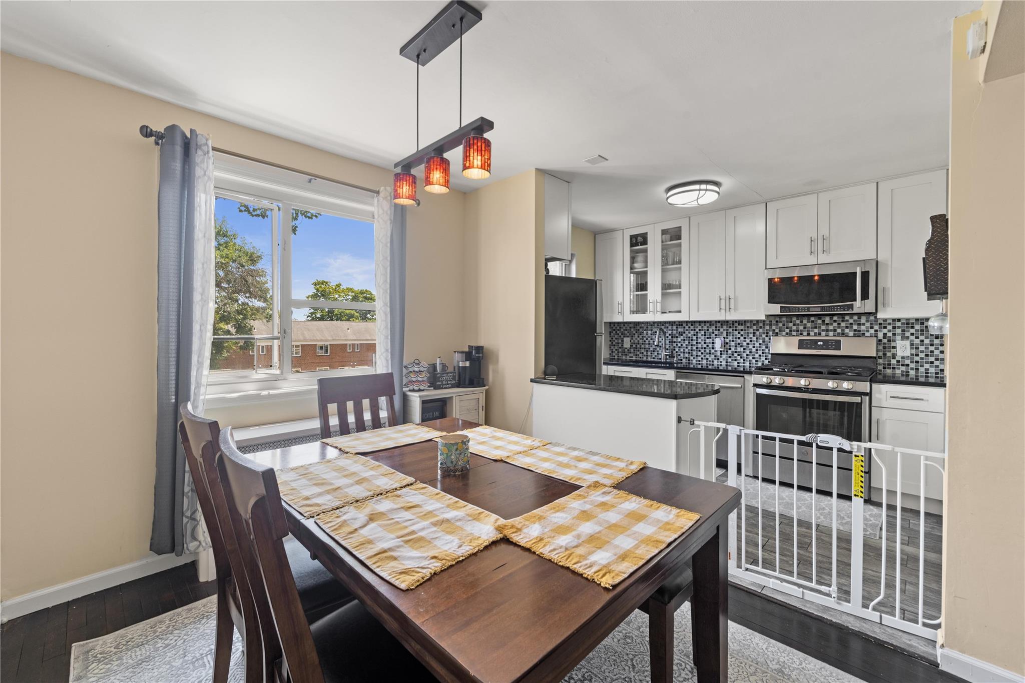 220-06 Stronghurst Avenue, Unit LOWR Queens, NY 11427 - Photo 12 of 19 a kitchen with a table chairs a sink dishwasher window and cabinets