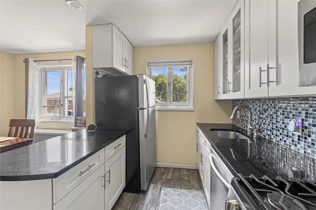 a kitchen with granite countertop a sink stove and refrigerator