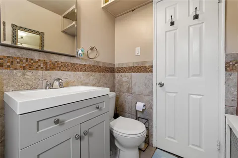 a bathroom with a sink a toilet and mirror