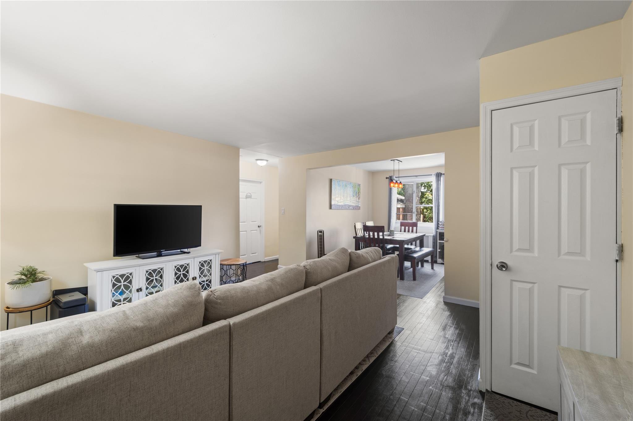 220-06 Stronghurst Avenue, Unit LOWR Queens, NY 11427 - Photo 4 of 19 a living room with furniture and a flat screen tv