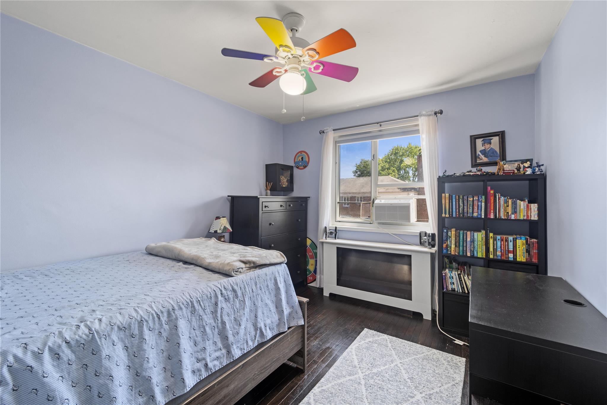220-06 Stronghurst Avenue, Unit LOWR Queens, NY 11427 - Photo 7 of 19 a bedroom with a bed bookshelf and a window
