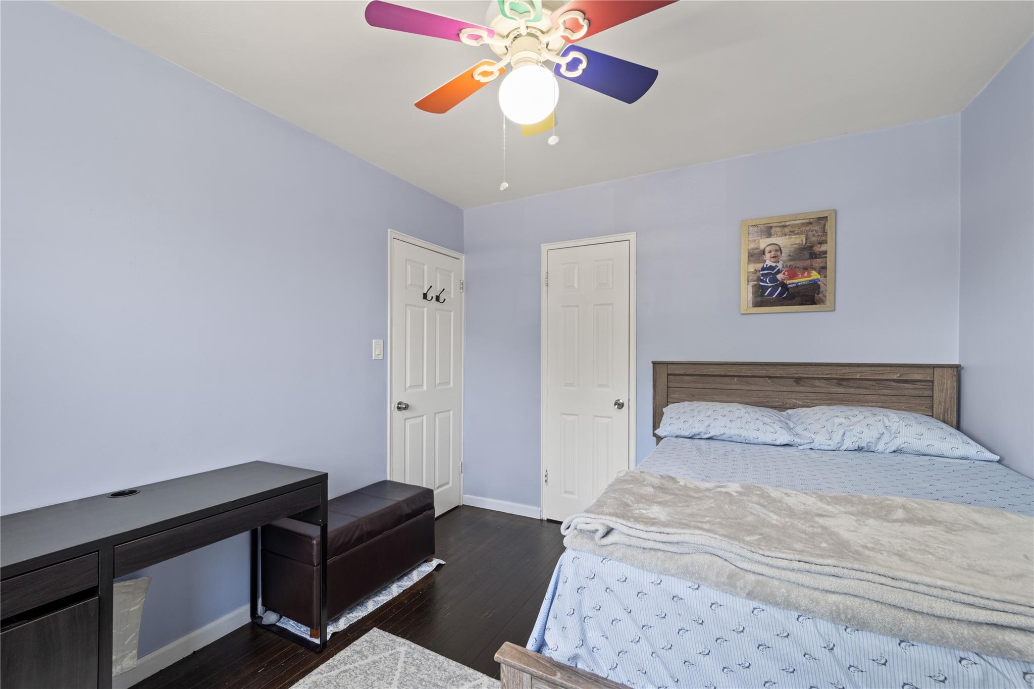 220-06 Stronghurst Avenue, Unit LOWR Queens, NY 11427 - Photo 8 of 19 a bedroom with a bed and a chandelier