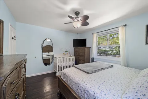 a bedroom with a bed and a flat tv screen on dresser