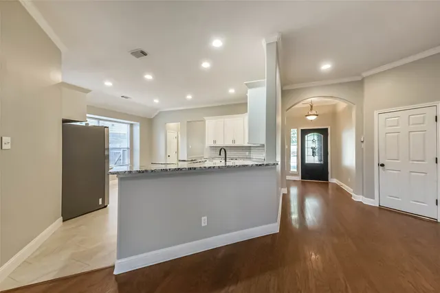 a kitchen with stainless steel appliances granite countertop a stove top oven a sink dishwasher and a refrigerator with wooden cabinets