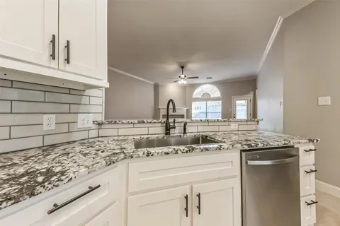 a bathroom with a granite countertop tub sink and mirror