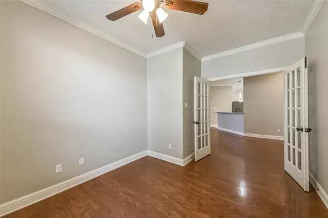 a view of an empty room with wooden floor and a fireplace