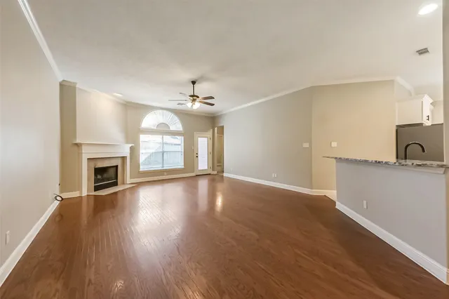 a view of an empty room and kitchen view