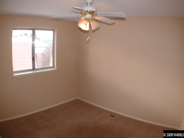 13081 Exinite Drive Reno, NV 89506 - Photo 5 of 9 an empty room with a window and a fan
