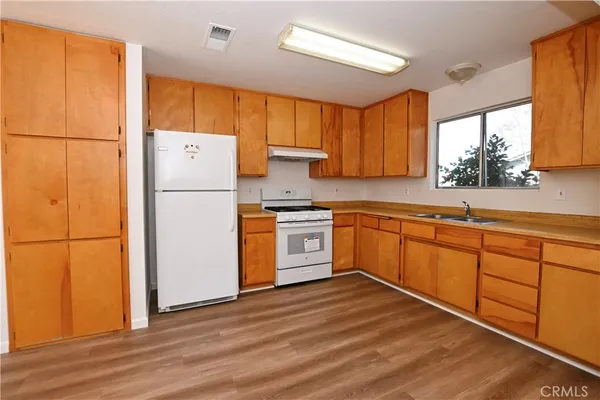 a kitchen with a refrigerator sink and cabinets