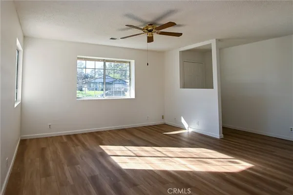 a view of an empty room and window and wooden floor