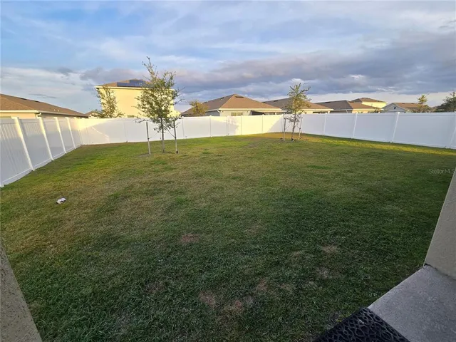 a view of a lake with a big yard and large trees