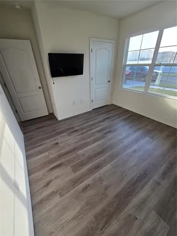 a view of a livingroom with wooden floor and white walls