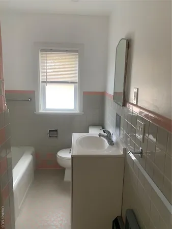 a bathroom with a toilet sink and mirror