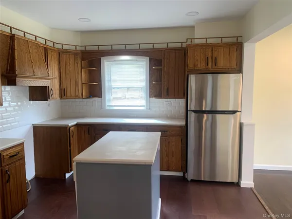 a kitchen with granite countertop a refrigerator and a stove top oven