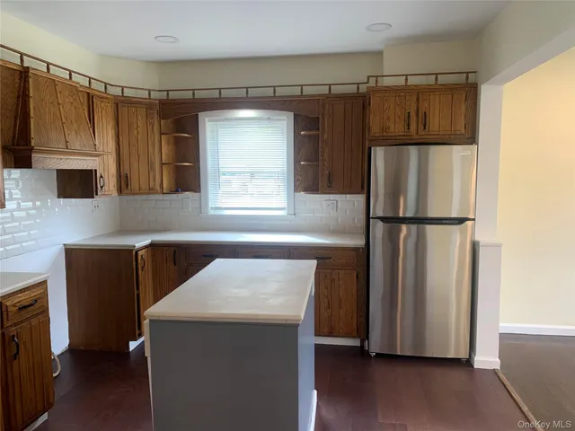 a kitchen with granite countertop a refrigerator and a stove top oven