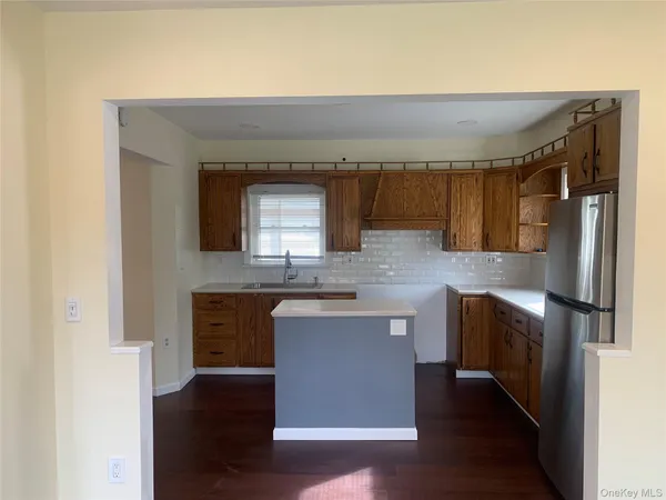 a kitchen with stainless steel appliances granite countertop a stove a sink and a refrigerator