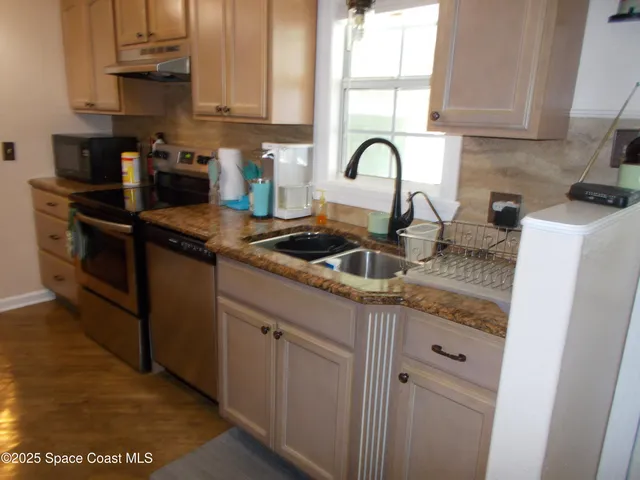 a kitchen with granite countertop white cabinets and sink