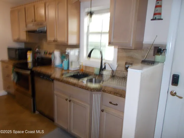 a kitchen with stainless steel appliances granite countertop a refrigerator a stove and a sink