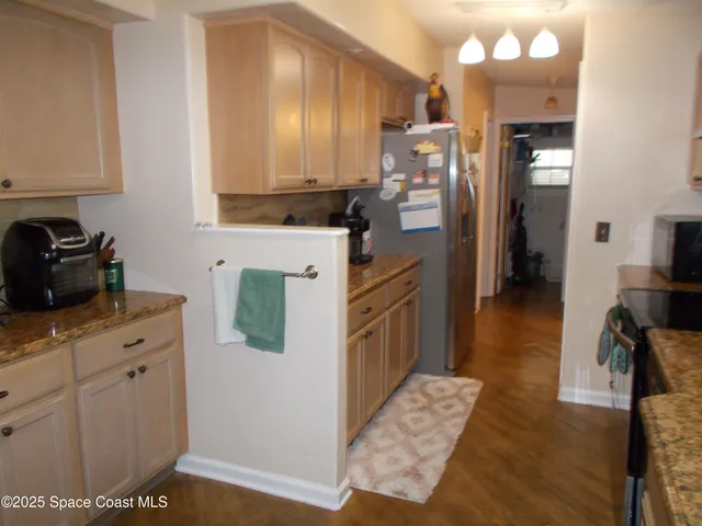 a kitchen with granite countertop white cabinets and white appliances