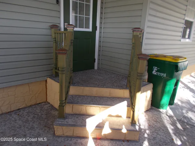 a view of a house with a small yard and wooden fence
