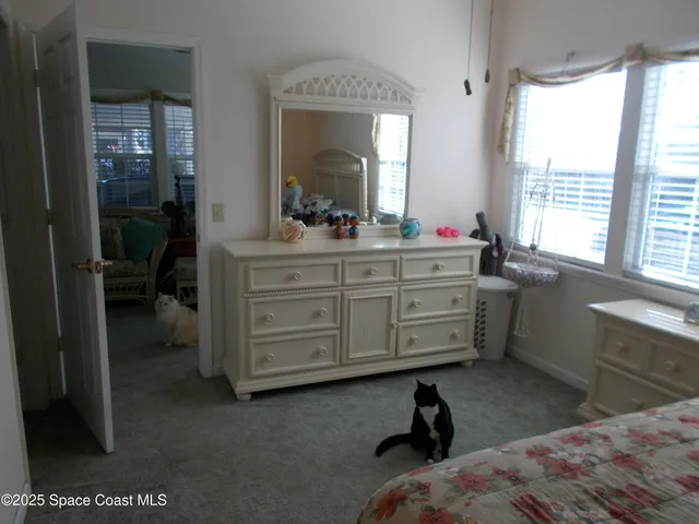 a room with a bed and a dresser next to a window