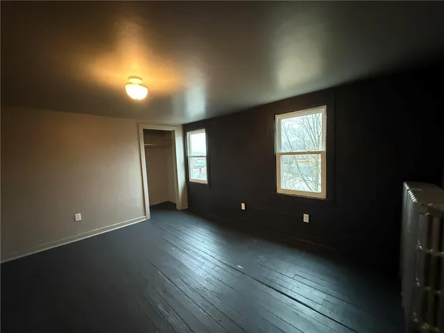 an empty room with windows and closet