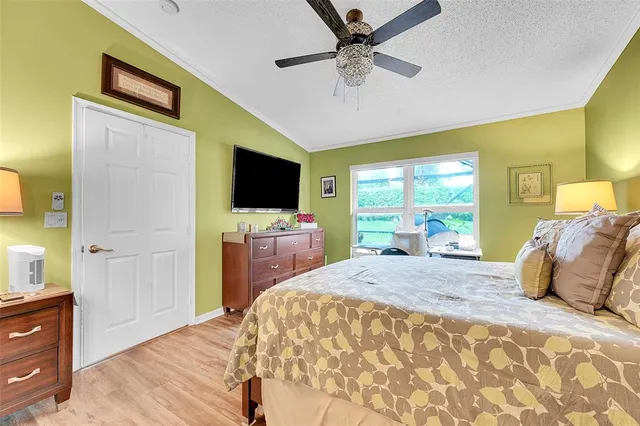 a bedroom with a bed and a flat tv screen on dresser