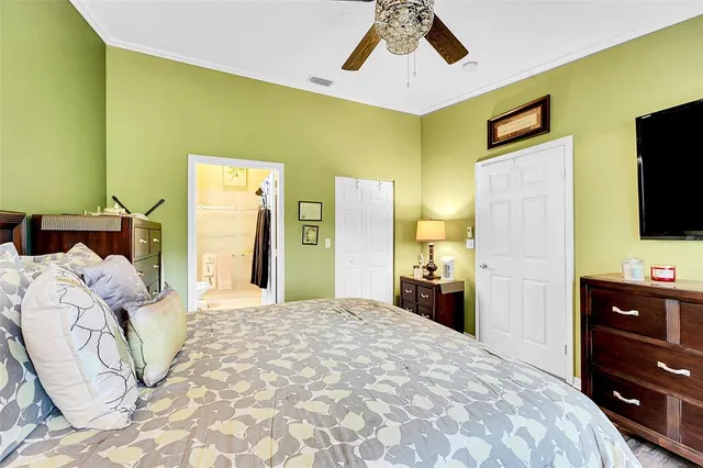 a bedroom with a bed and a flat tv screen on dresser