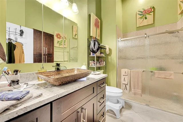 a bathroom with a granite countertop sink mirror vanity and toilet