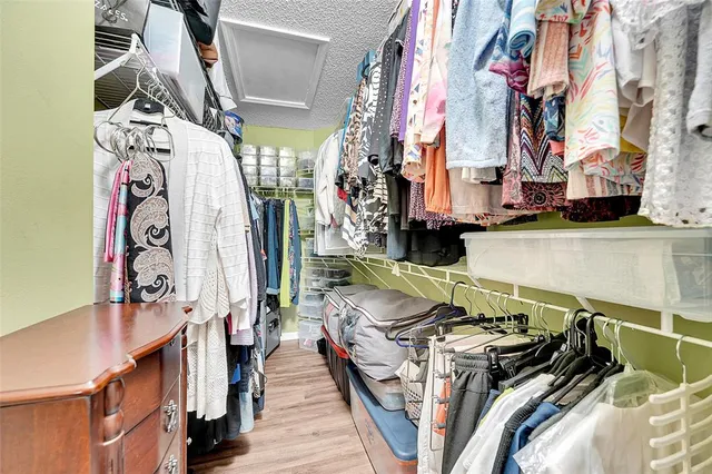 a view of walk in closet with clothes and shoes