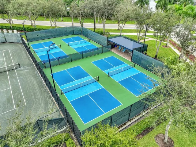 a view of a tennis ground with large trees