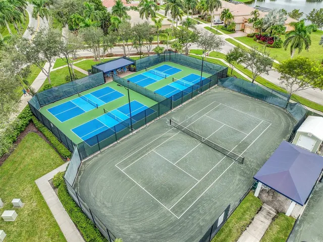 a view of a tennis ground with large trees
