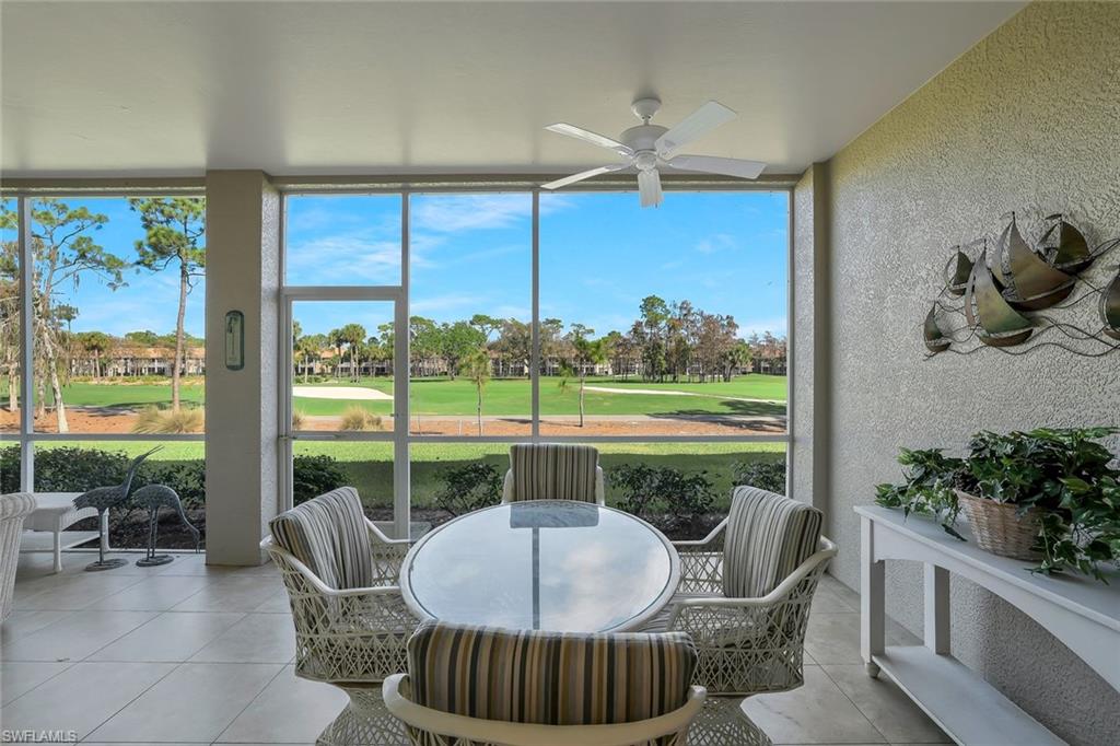 Sunroom with view of golf course, ceiling fan, and outdoor dining area