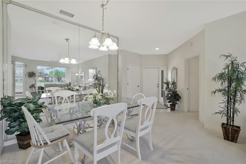 8457 Radcliffe Terrace, Unit 102 Naples, FL 34120 - Photo 11 of 33 Dining room featuring hanging lights and light carpet