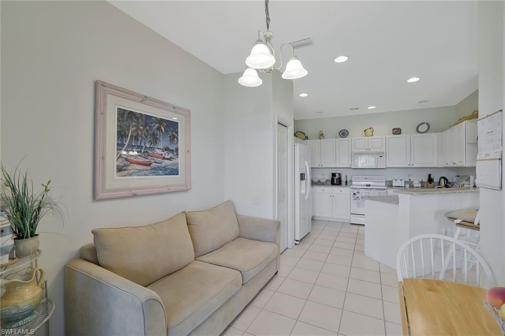 8457 Radcliffe Terrace, Unit 102 Naples, FL 34120 - Photo 12 of 33 Living area with hanging lights and light tile patterned flooring