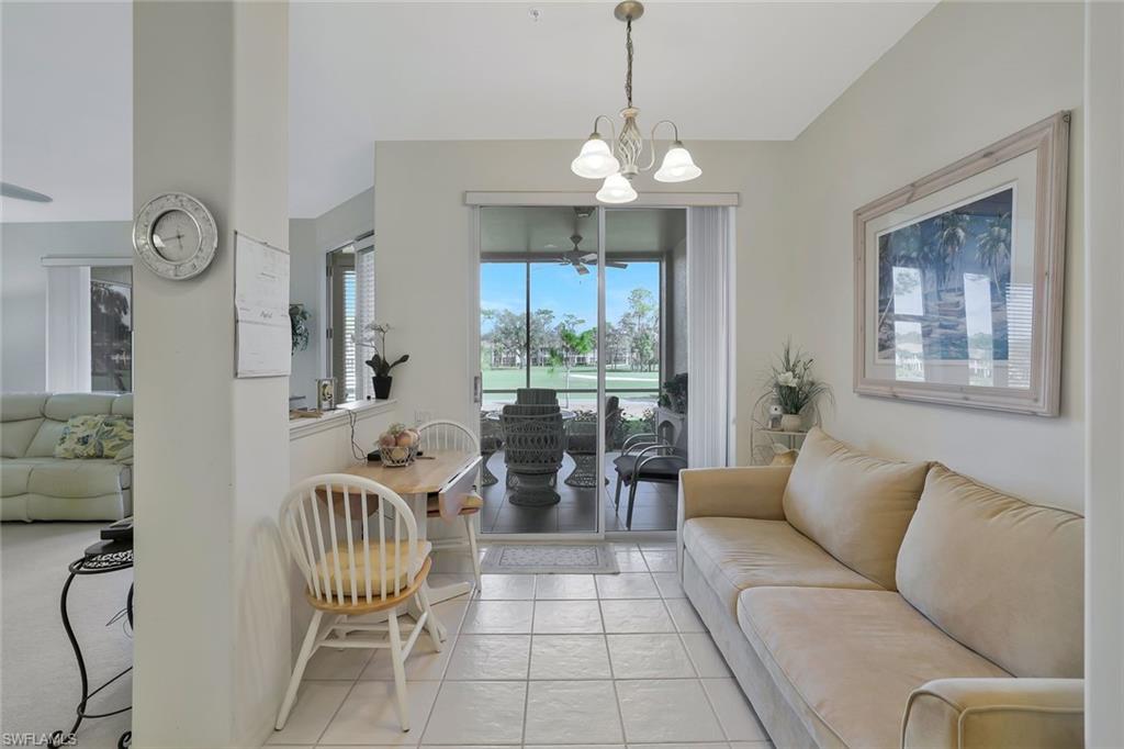 8457 Radcliffe Terrace, Unit 102 Naples, FL 34120 - Photo 13 of 33 Living room featuring a chandelier and light tile patterned floors
