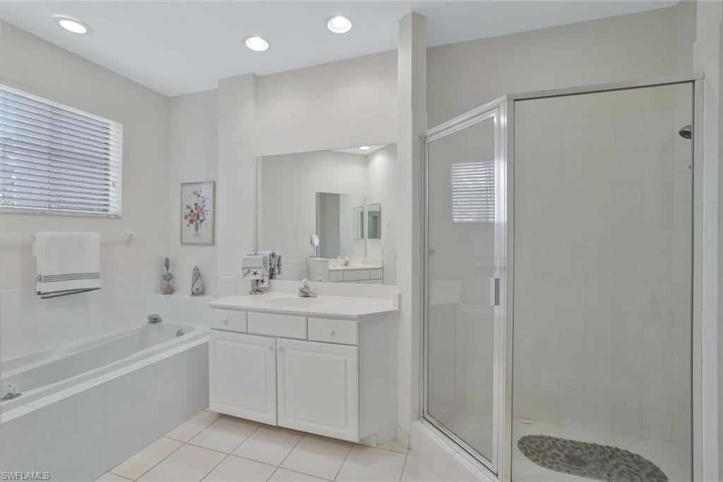 8457 Radcliffe Terrace, Unit 102 Naples, FL 34120 - Photo 16 of 33 Bathroom featuring a shower stall, light tile patterned floors, a bath, vanity, and recessed lighting