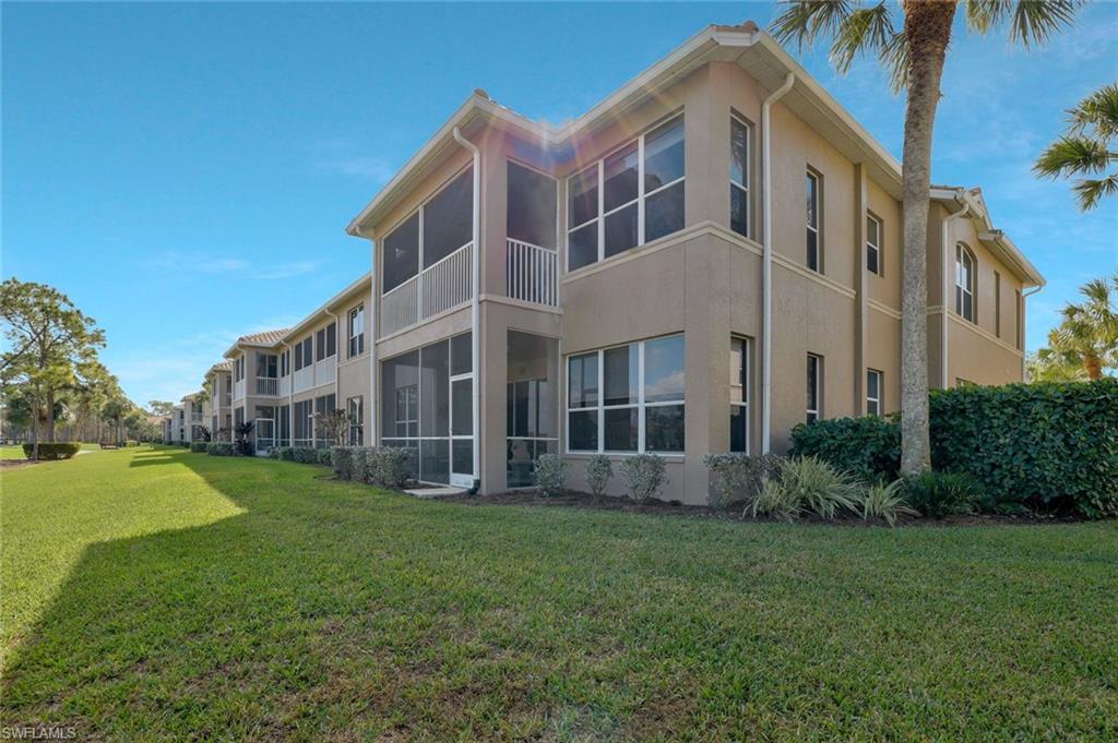 8457 Radcliffe Terrace, Unit 102 Naples, FL 34120 - Photo 23 of 33 Back of property featuring a sunroom, stucco siding, a lawn, and a balcony